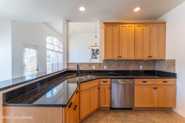 kitchen featuring tasteful backsplash, dark stone counters, dishwasher, vaulted ceiling, and a sink