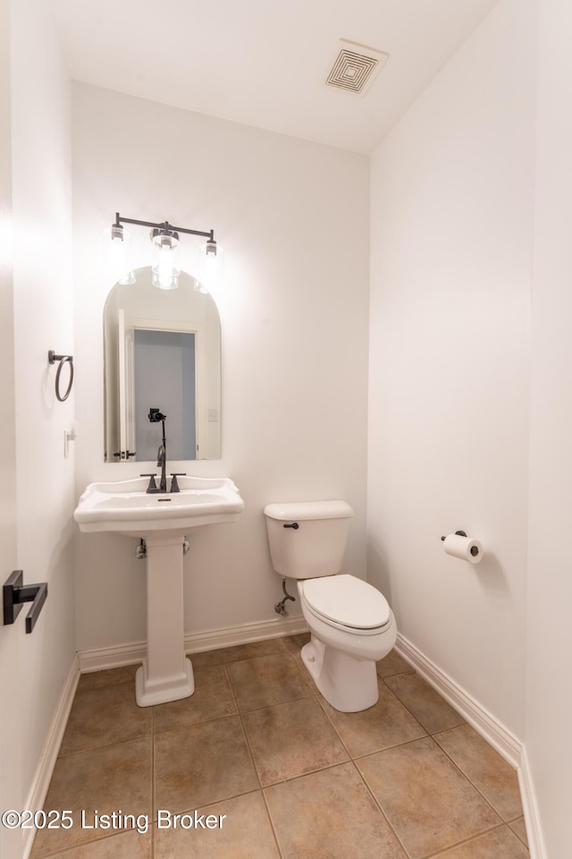 bathroom featuring baseboards, visible vents, and toilet