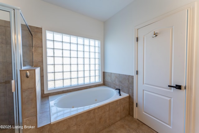 full bathroom with a stall shower, a bath, and tile patterned floors