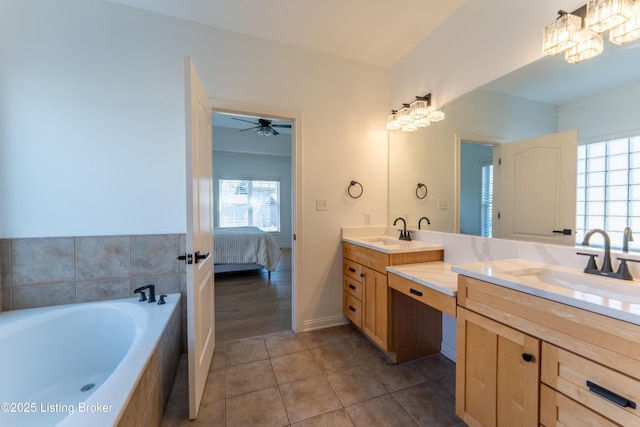 ensuite bathroom with ceiling fan, ensuite bathroom, tile patterned floors, a bathtub, and vanity