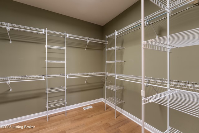 walk in closet with visible vents and wood finished floors