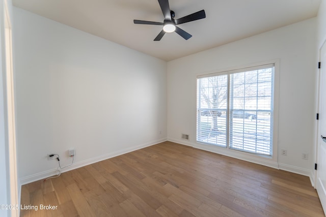 empty room featuring light wood-style flooring, visible vents, ceiling fan, and baseboards