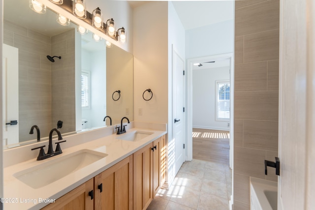 full bath with a shower, double vanity, a sink, and tile patterned floors