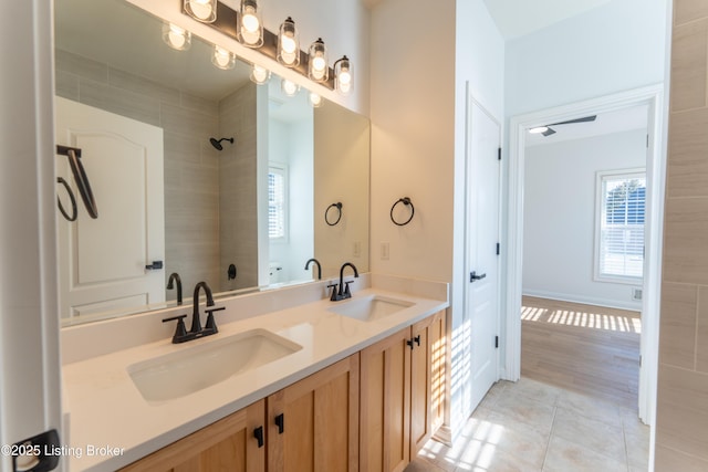 full bath featuring double vanity, walk in shower, a sink, and tile patterned floors