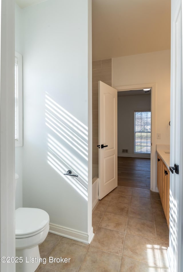 bathroom featuring toilet, vanity, baseboards, and tile patterned floors