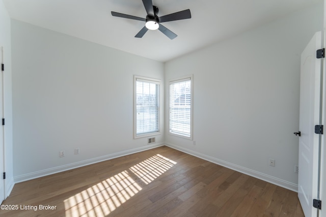 unfurnished room featuring ceiling fan, wood finished floors, visible vents, and baseboards