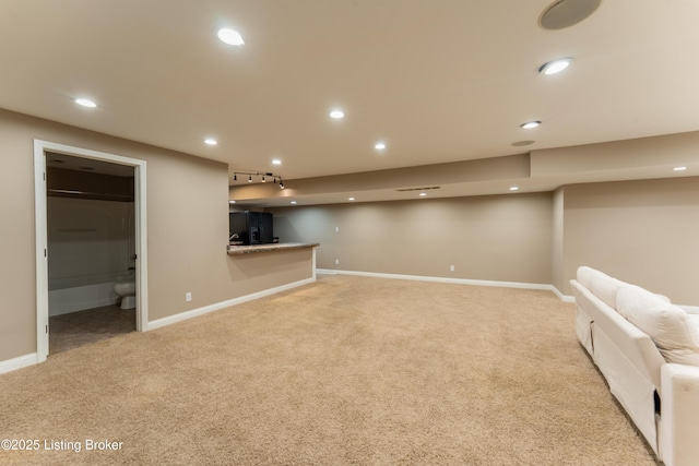 finished basement featuring recessed lighting, baseboards, carpet flooring, and black fridge with ice dispenser