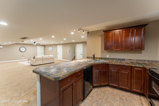 kitchen with visible vents, open floor plan, a peninsula, black appliances, and a sink