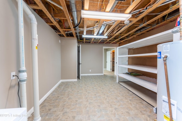 unfinished below grade area featuring water heater and baseboards