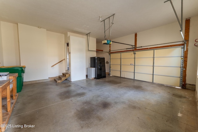 garage featuring a garage door opener and black fridge