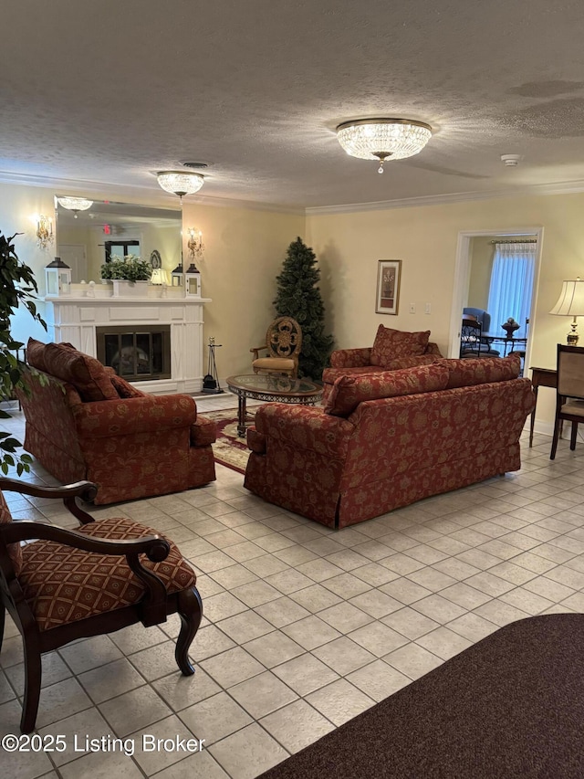 living room with a textured ceiling, ornamental molding, light tile patterned flooring, and a glass covered fireplace