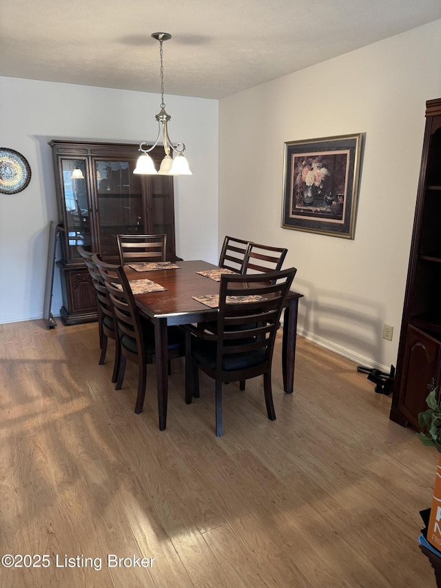 dining space featuring baseboards and wood finished floors