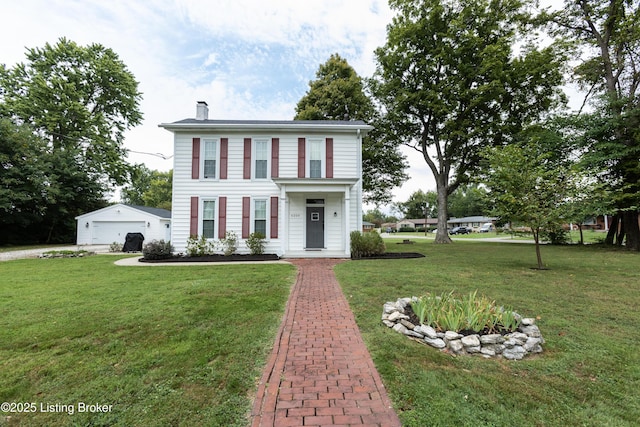 view of front of home featuring an outbuilding, a garage, a front lawn, and a chimney