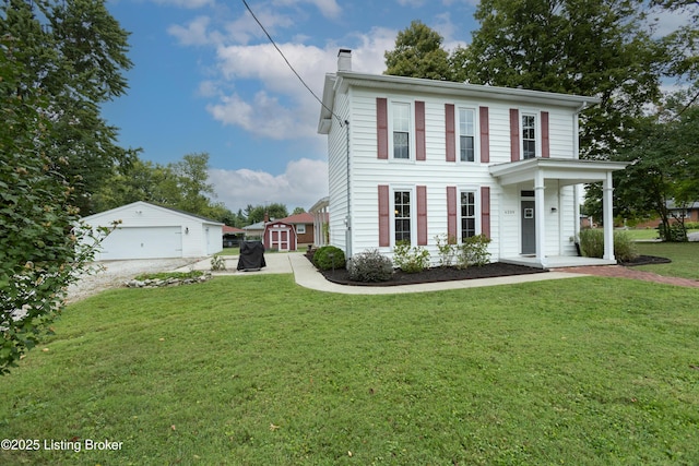 view of front facade featuring a front lawn, an outbuilding, a garage, and a chimney