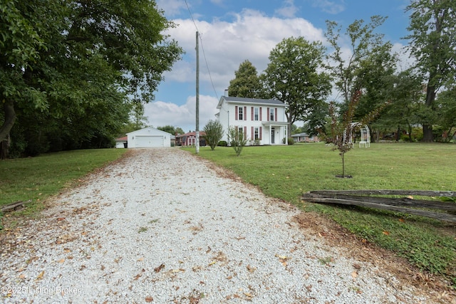 view of front facade featuring an outdoor structure, a garage, and a front yard