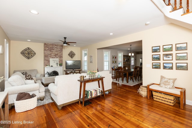 living room with hardwood / wood-style floors, stairway, recessed lighting, a fireplace, and ceiling fan