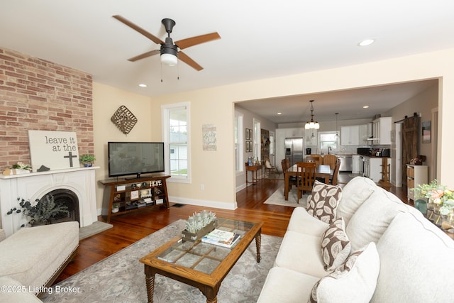 living area with recessed lighting, baseboards, wood finished floors, and a fireplace