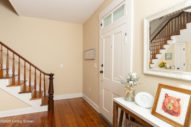 entrance foyer with dark wood-style floors, stairs, and baseboards