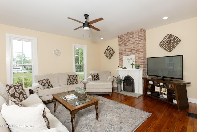 living area with visible vents, dark wood-type flooring, a ceiling fan, recessed lighting, and a large fireplace