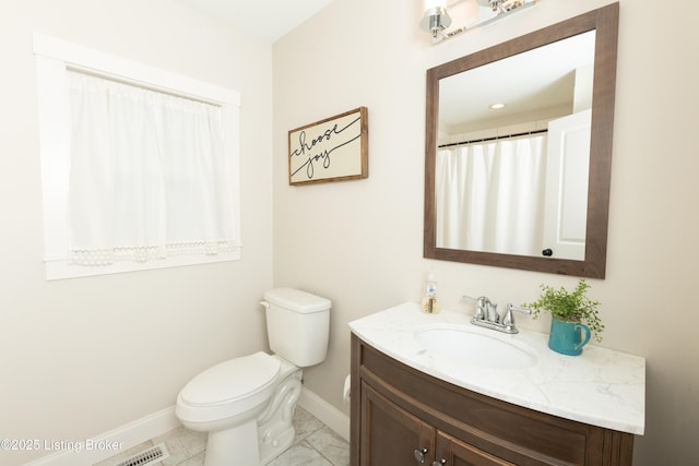 bathroom featuring vanity, toilet, and baseboards