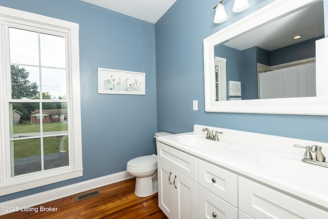 full bath with visible vents, wood finished floors, baseboards, and a sink