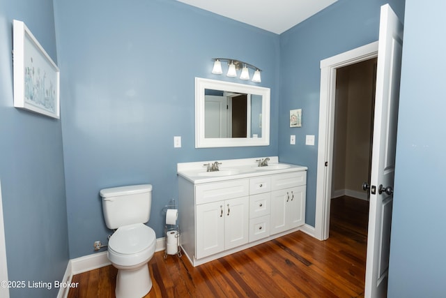 bathroom with a sink, toilet, and wood finished floors