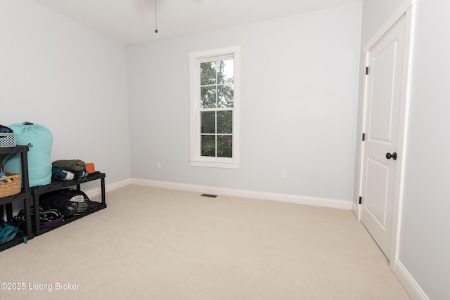 interior space featuring visible vents, light carpet, and baseboards