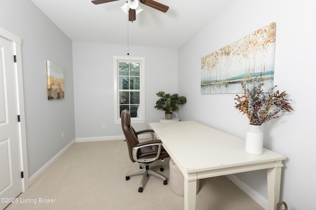 home office featuring ceiling fan, baseboards, and light carpet