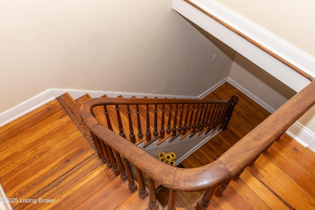 stairs featuring hardwood / wood-style flooring and baseboards