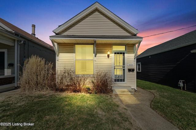 shotgun-style home featuring a yard