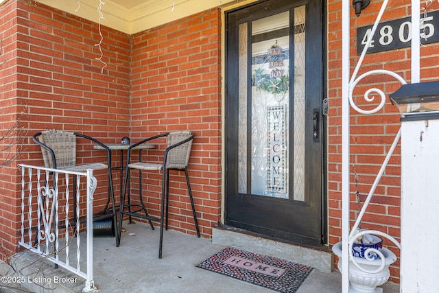 entrance to property featuring brick siding