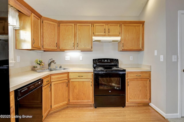 kitchen with light countertops, a sink, under cabinet range hood, and black appliances