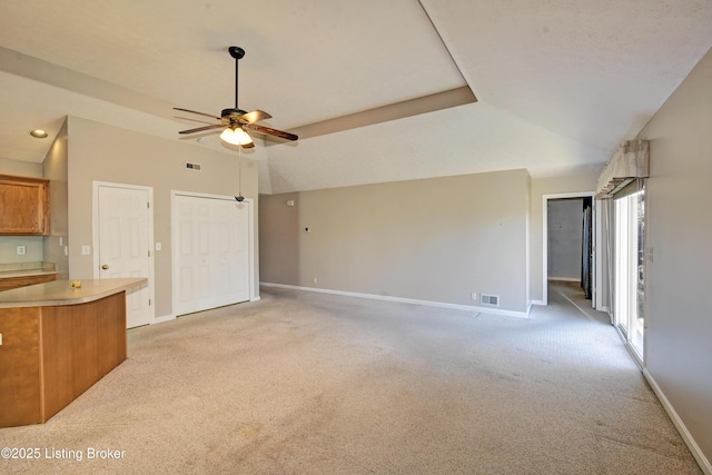 unfurnished living room featuring visible vents, baseboards, a ceiling fan, and light colored carpet