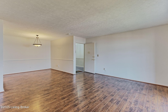 empty room featuring a textured ceiling, baseboards, and wood finished floors