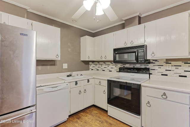 kitchen featuring freestanding refrigerator, a sink, range with electric cooktop, black microwave, and dishwasher