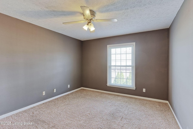 carpeted empty room with ceiling fan, baseboards, and a textured ceiling