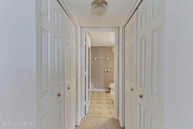 hallway with a textured ceiling