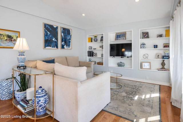 living area with built in features, recessed lighting, vaulted ceiling, wood finished floors, and baseboards