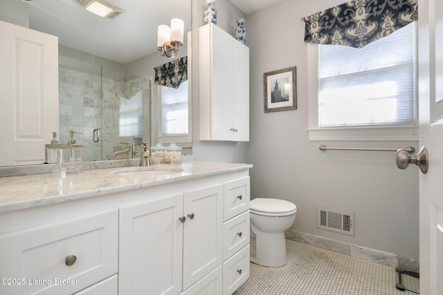 bathroom featuring toilet, vanity, visible vents, baseboards, and a shower stall