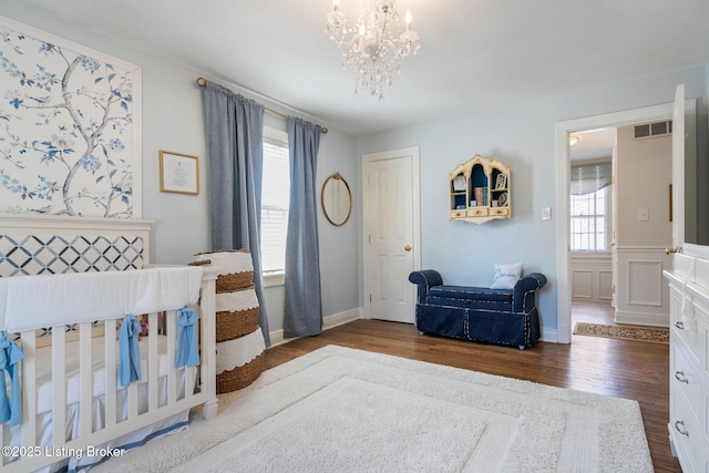 bedroom featuring visible vents, a notable chandelier, and wood finished floors