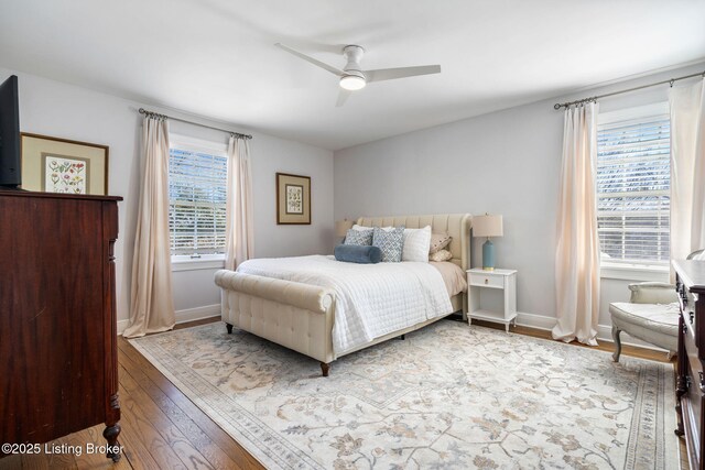 bedroom with ceiling fan, wood-type flooring, and baseboards