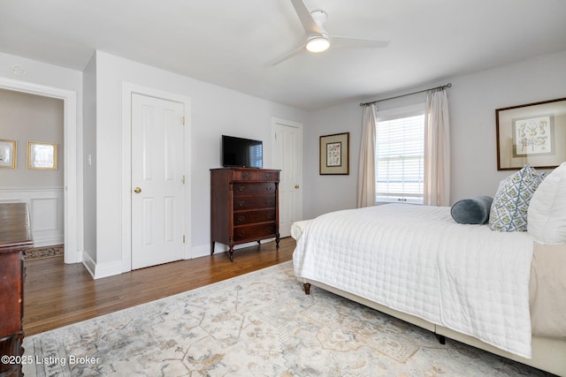 bedroom with ceiling fan, wood finished floors, and baseboards