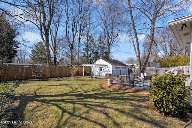 view of yard featuring a patio, an outdoor structure, and a fenced backyard