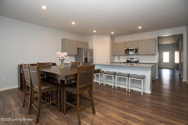 dining space with recessed lighting, dark wood finished floors, and baseboards