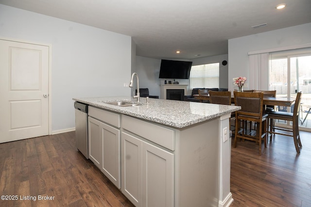 kitchen featuring dishwasher, dark wood finished floors, a sink, and visible vents