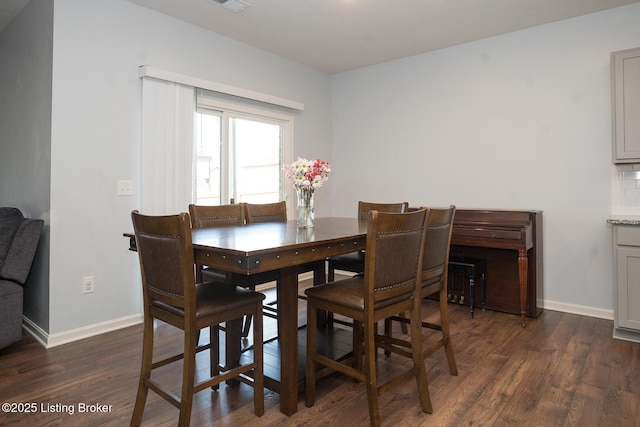dining room featuring visible vents, baseboards, and dark wood finished floors