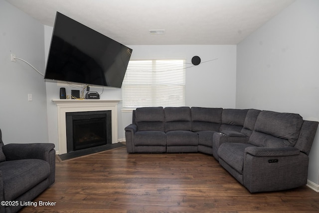 living room featuring a fireplace, wood finished floors, and visible vents