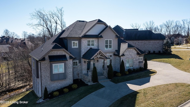 craftsman inspired home featuring a front lawn and stone siding