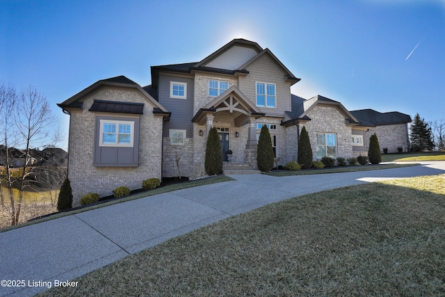 craftsman house featuring stone siding and a front yard