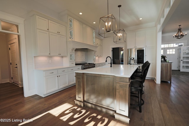 kitchen with a sink, a notable chandelier, white cabinets, and gas range oven